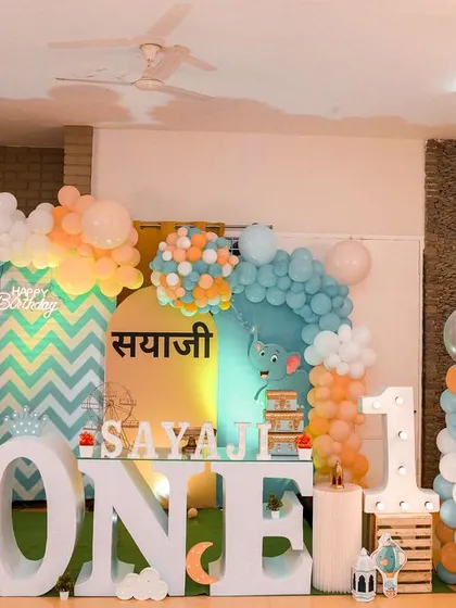 A wide shot of an elegant first birthday setup, showing the beautiful decor, balloons, and personalized touches.