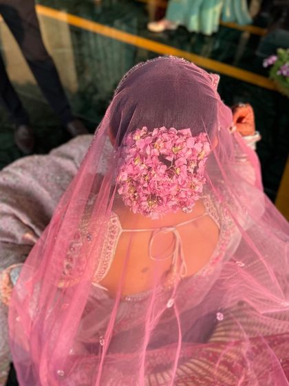 A beautiful shot of the floral bun seen through the bride's pink veil. This shows how the hairstyle can be a feature even when partially covered.