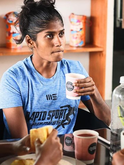 An athlete refueling between sessions. Proper nutrition and hydration are emphasized as critical components of recovery and performance.
