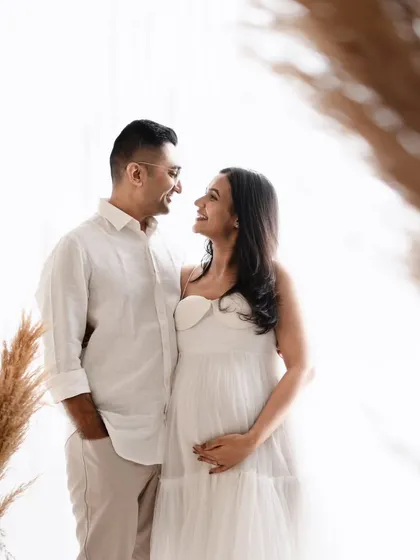 I love using foreground elements like this pampas grass to create depth. It frames the couple perfectly, drawing your eye to their happy interaction in this light and airy studio shot.