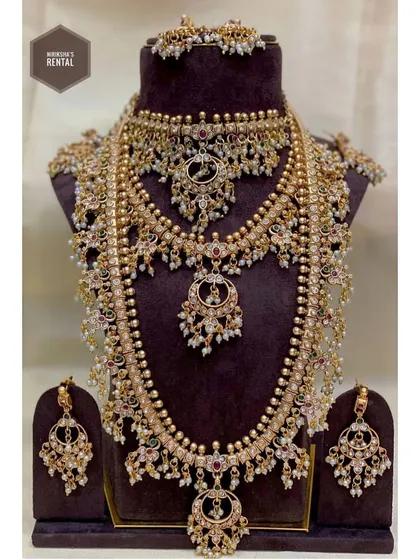 I believe in providing an "ekdum complete look," which is why most of my outfits come with jewellery. This is an example of a full bridal jewellery set available for rent, featuring multiple necklaces, earrings, and a maang tikka, all designed to complement a traditional bridal outfit.