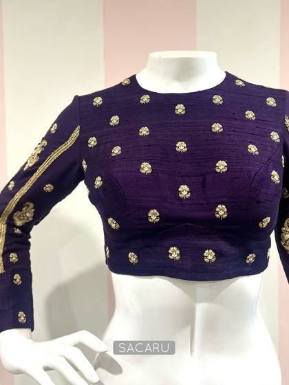 Understated elegance defines this intricately hand-embroidered, full-sleeve blouse in a deep purple raw silk, featuring a wide back opening.