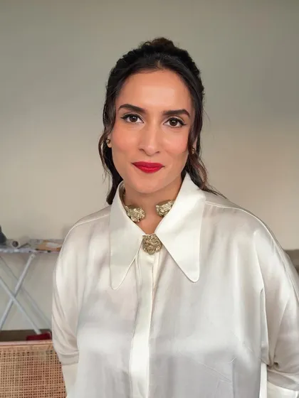 The front view of this classic glam look. The half-up hairstyle is paired with a sharp winged liner and a bold red lip for a powerful statement.