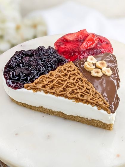 A close-up of our 4-in-1 heart-shaped cheesecake. It's the perfect dessert for couples or friends who have different tastes but want to share a special treat.