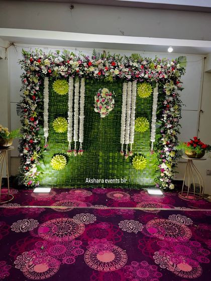 This elegant naming ceremony backdrop is made from woven banana leaves and adorned with garlands of fresh white jasmine. The floral frame adds a touch of grandeur to the setting.