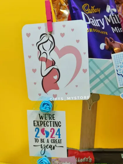 A sweet "mom-to-be" card clipped onto the baby shower hamper, celebrating the beautiful journey of pregnancy.