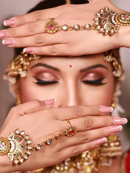 This shot highlights the importance of cohesive styling, from the winged eyeliner to the elegant french manicure and hathphool.