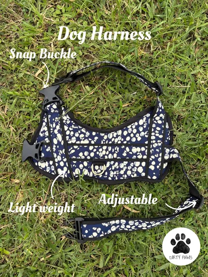 A detailed product shot of the harness, laid out to show its construction. The annotations point out the adjustable straps, lightweight material, and secure snap buckles.