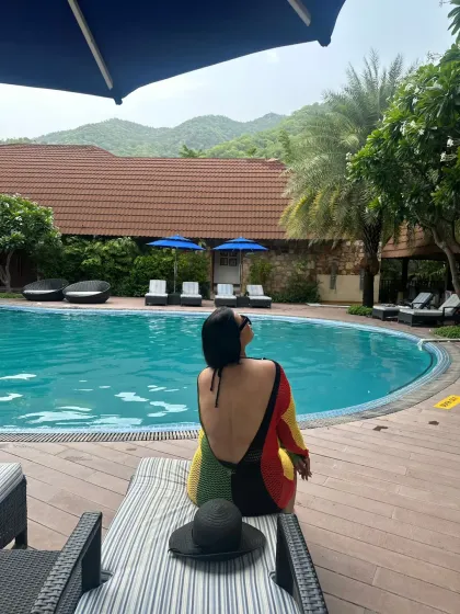 A moment of peace by the pool. This backless, multi-colored cover-up is a stylish and slightly daring choice for a resort setting.