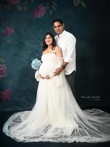 A classic couple's portrait with a touch of color. The blue bouquet adds a soft accent to this otherwise timeless and elegant white gown photo.