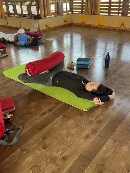 A student relaxes in a supported side-lying pose, a key part of the surrender and release that Yin yoga offers.