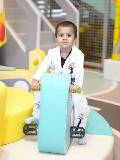 This sharply dressed toddler is enjoying a ride on one of our soft, pedal-powered bikes.