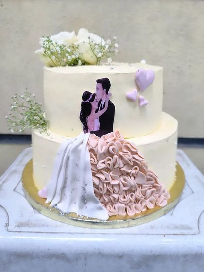 And forever to go. This romantic two-tier cake features an edible print of a couple, with the bride's dress extended into beautiful, hand-piped fondant ruffles for a 3D effect.