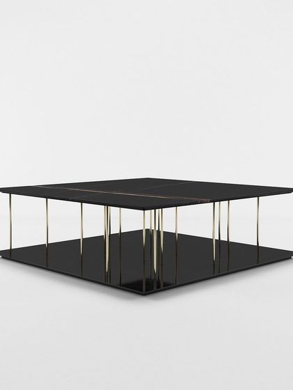 A studio view of our modern two-tier center table, highlighting its minimalist design and the striking contrast between the black surfaces and metallic supports.