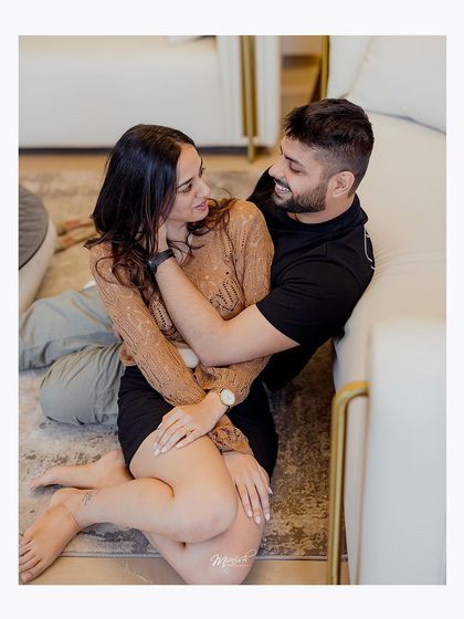 A tender moment on the floor, showing the comfort and intimacy the couple shares in their personal space.