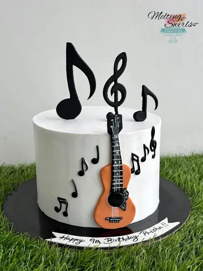 An elegant cake for a young music lover. This clean white cake is decorated with a handmade fondant guitar and edible music notes.