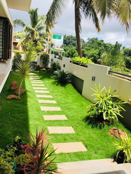 A landscaped setback with a stepping stone path provides a green buffer between the house and the property line.