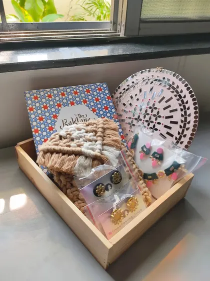 A lovely custom hamper featuring a neutral-toned macrame purse, a box of delicious Baklava, a statement necklace, and two pairs of my handmade studs. I can create these for any occasion.
