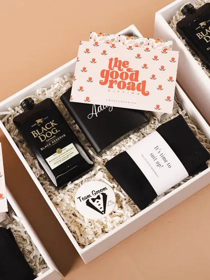 A sleek and stylish gift box for the groomsmen. This hamper includes a personalized hip flask with his name, a 'Team Groom' badge, and other essentials to thank your guys for standing by you.
