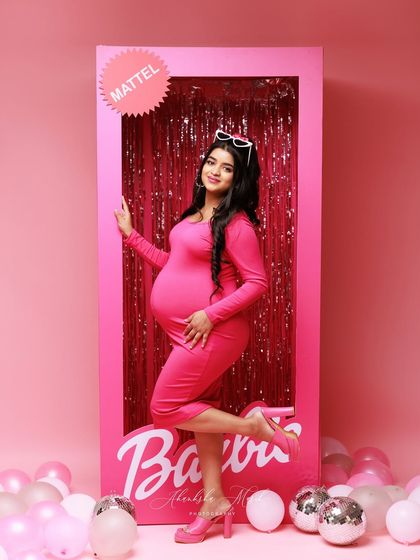 Come on Barbie, let's go party! This fun and vibrant shot places the mom-to-be inside a life-sized Barbie box, creating a playful and unforgettable maternity portrait.