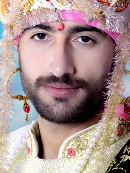 A close-up portrait of the groom, focusing on the details of his traditional Himachali turban and his confident expression.