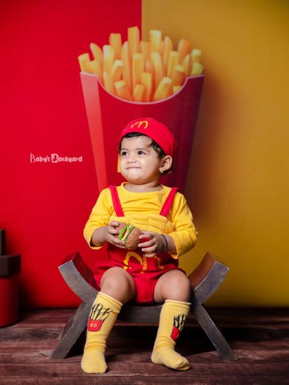 Serving up smiles with an extra side of cuteness. This little one is enjoying his burger and fries.