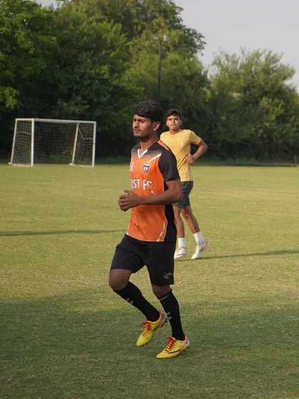 A senior player jogging during the warm-up phase of training.