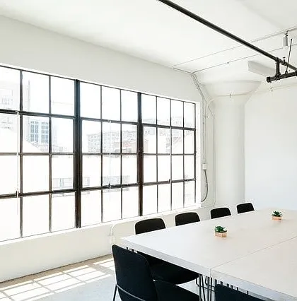 A bright and minimalist commercial meeting room. I provide professional painting services for offices and businesses, creating clean, productive environments with a crisp white finish.