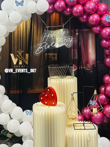 A detailed shot of the pink and white birthday decoration, showing our logo and the small props that bring the theme together.