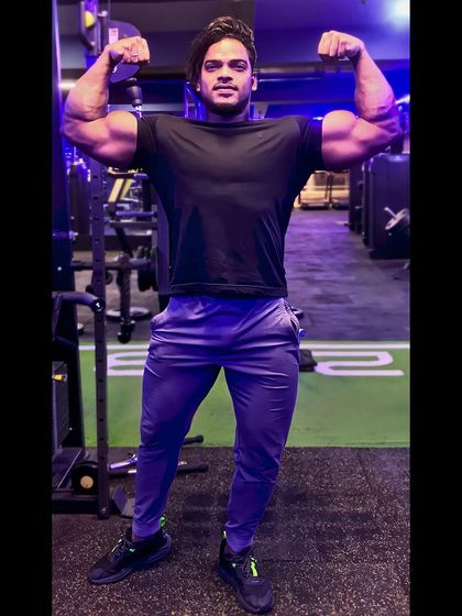 Your attitude determines your direction. This double biceps pose showcases a physique built on a positive mindset and relentless hard work.