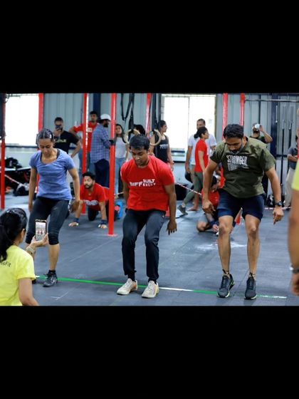 Athletes in the middle of a burpee set during a competition workout. This full-body movement is a true test of grit and conditioning.