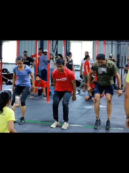 Athletes in the middle of a burpee set during a competition workout. This full-body movement is a true test of grit and conditioning.