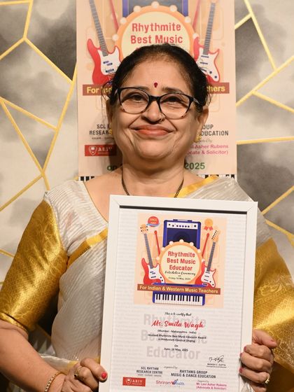 Ms. Smita Wagh proudly holding her Rhythmite Best Music Educator Award for Hindustani Classical Singing.