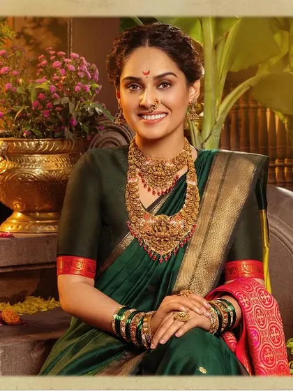 A portrait of timeless Maharashtrian elegance. This look, created for a Ranka Jewellers campaign, features a classic dark green saree paired with heavy, traditional gold jewelry, a delicate nath, and a radiant smile, embodying the 'सोनेरी सण' or golden festival spirit.