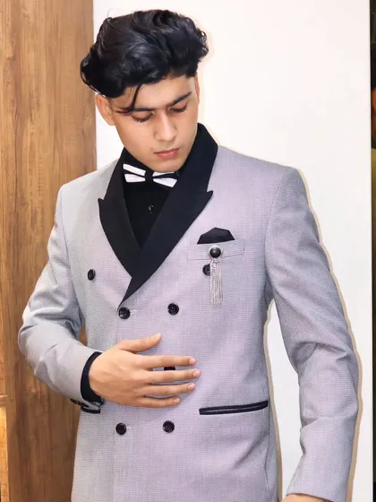 A close up of the pinstripe double breasted suit. The precise tailoring ensures the buttons align perfectly and the jacket drapes correctly.