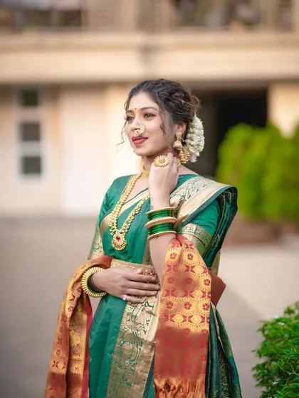 A close-up of the Nauvari look, highlighting the intricate details of the drape, the traditional jewelry, and the floral hair accessory (gajra). Every element works together to create a complete picture.