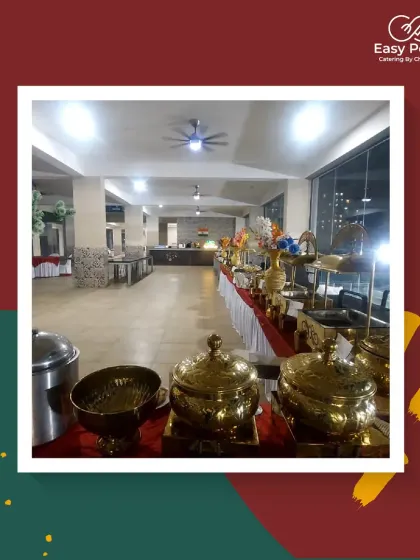 A wide shot of our catering setup in a spacious banquet hall, showing the full length of the buffet line. We can easily scale our services for large indoor gatherings.