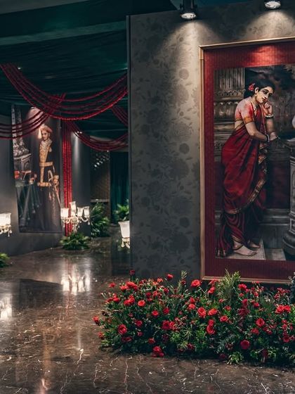 The entrance to the sangeet, where guests are greeted by a gallery of paintings and lush floral arrangements. This immersive entry sets the stage for the night's narrative.