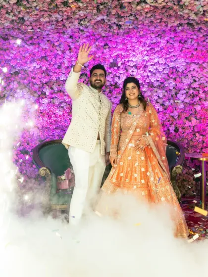 The newly engaged couple makes a grand entrance with smoke and confetti, waving to their loved ones.