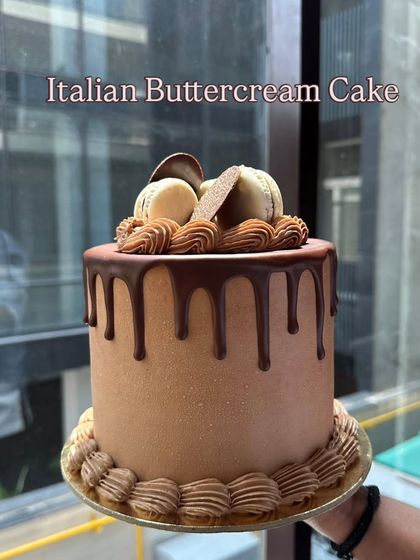 This is my Italian Buttercream Cake, featuring a smooth chocolate finish, a perfect drip, and topped with macarons. It's as delicious as it is beautiful.
