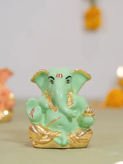 A lovely mint green Ganesha idol, finished with gold details. This piece is ideal for those who love to incorporate unique colors into their festive or everyday spiritual decor.