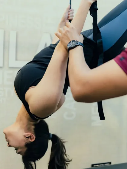 This advanced hanging stretch on the Cadillac requires both strength and flexibility. It's a testament to what you can achieve with consistent practice and expert guidance.