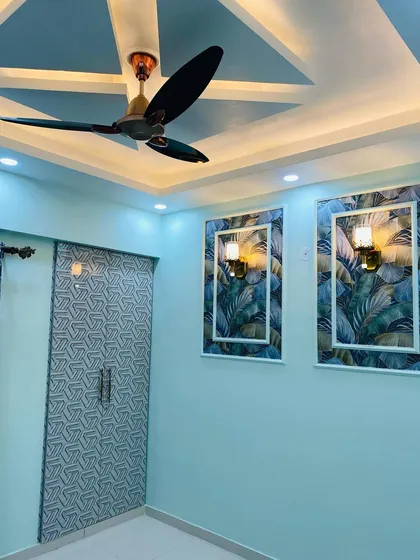 Another shot of the blue bedroom, highlighting the false ceiling design that complements the room's modern aesthetic.