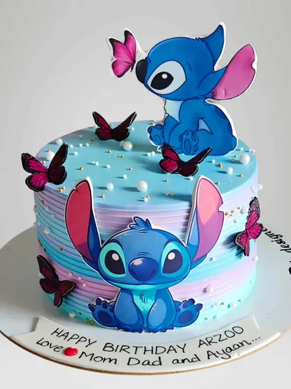 A cute Stitch-themed cake with a pastel color palette. This whipped cream cake is adorned with butterflies, creating a sweet and gentle design for a Disney fan.