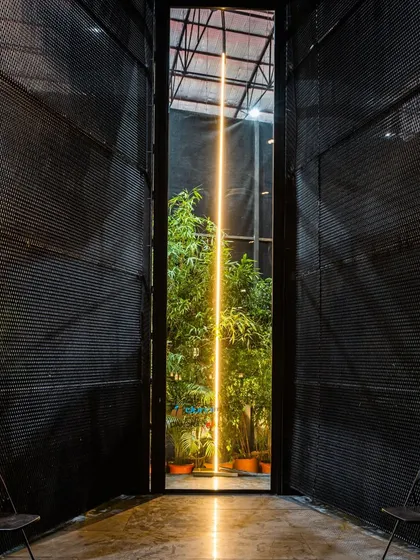 A close-up of the "line of light" installation within the pavilion. The simple, powerful gesture creates a focal point and a moment of wonder within the dark, mesh-enclosed space.