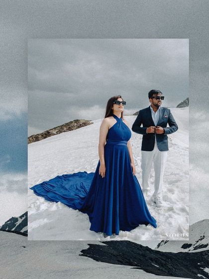 An artistic, framed shot of the bride's dramatic blue dress against the white snow.