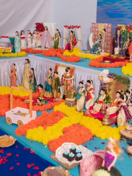 Sheetal's baby shower `rukhwat`, a vibrant and joyful display with dolls dressed in colorful sarees, surrounded by marigold flowers.