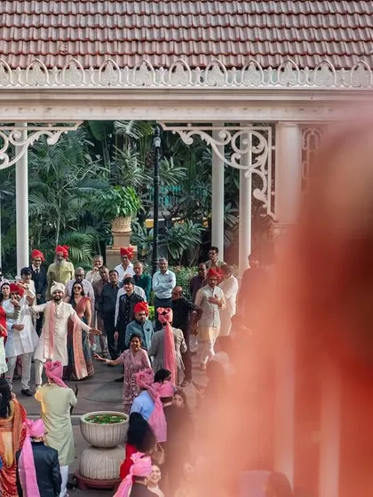A creative shot of the baraat from the bride's perspective, looking down from the balcony. It captures her anticipation and a unique view of the celebration below.
