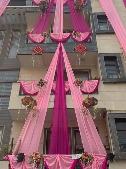 A modern house decorated with elegant pink and magenta drapes. The clean lines of the draping complement the contemporary architecture of the building.
