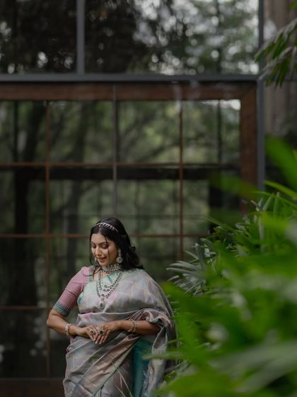 The model's pose is graceful and poised, reflecting the elegance of the multi-tonal silk saree.